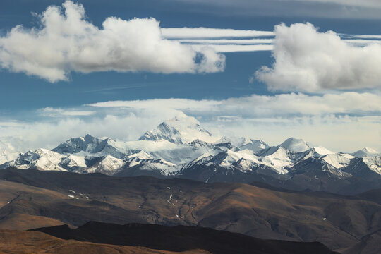 View of the snow-capped peaks of Mount Everest under a cloudy sky in the Himalayas in Tibet, China.