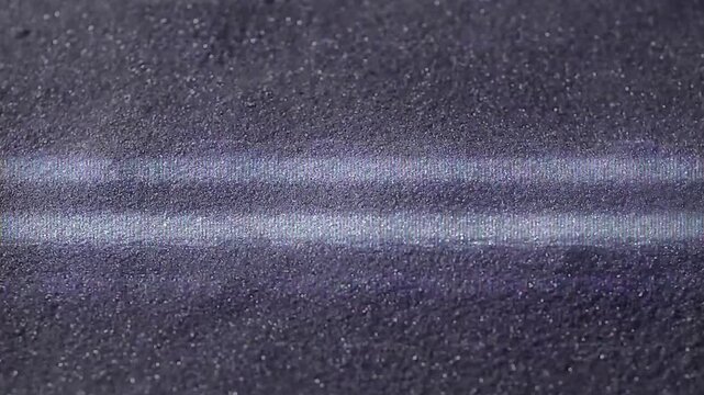 Close-up texture of a dark asphalt road with two white lines, emphasizing the grainy surface and painted markings