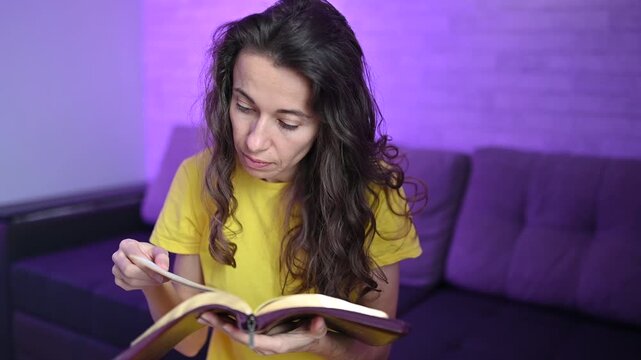 Woman reading the bible and turning pages Devout christian studying scripture and deepening her faith at home