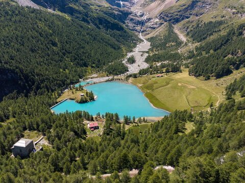 Aerial view of the turquoise Lago di Palu and the Wasserkraftwerk Palu hydroelectric power plant infrastructure in the alpine valley of Poschiavo, Grisons, Switzerland.