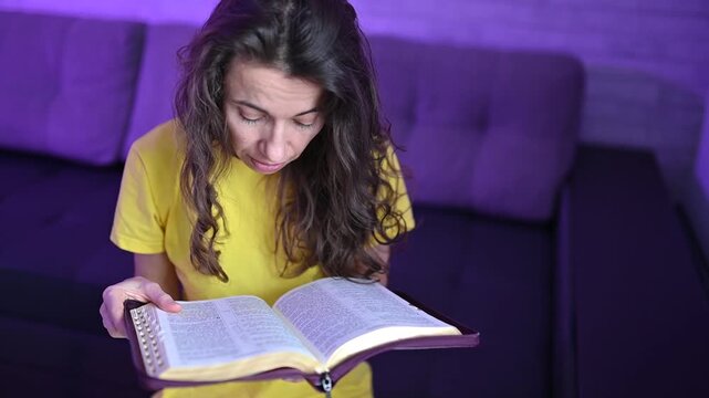 Woman reading the bible and turning pages Devout christian studying scripture and deepening faith at home