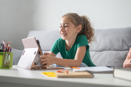 Schoolgirl using digital tablet for online learning at home