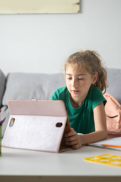 Schoolgirl using digital tablet for online learning at home