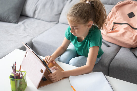 Schoolgirl using digital tablet for online learning at home