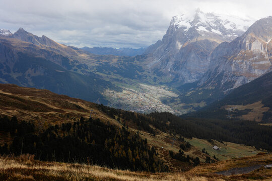 View of Kleine Scheidegg mountain pass with autumn foliage, alpine meadows, and snow-capped peaks in the Bernese Alps, Lauterbrunnen, Canton of Bern, Switzerland.