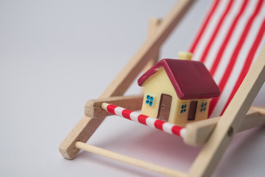 Happy home relax in red beach chair with white background copy space. Low interest rate mortgage loan, low house price, financial freedom, independence, no financial problems concept.
