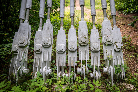 Heavy Steel Tension Rods Anchor a Suspension Bridge Beside the Forest