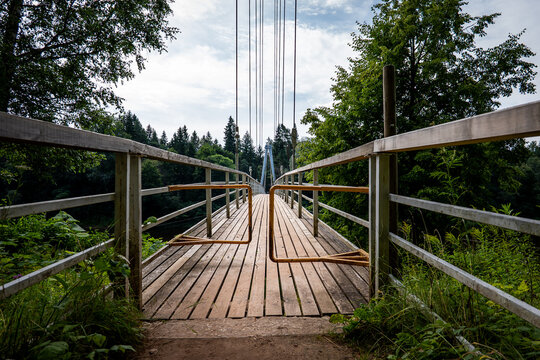Open Metal Barriers Mark the Entrance to a Wooden Suspension Bridge