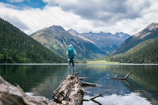 Hiking woman on a one plank bridge in high altitude mountains