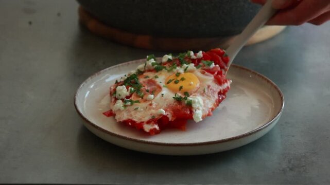 Traditional Shakshuka Served in Ceramic Dish with Poached Eggs and Fresh Herbs