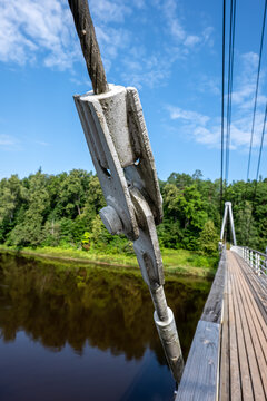 Steel Cable Connector Supports a Wooden Suspension Bridge Over a River