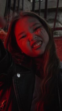 POV of Asian child with spooky Halloween makeup growling at camera. Clip is ideal for autumn holiday marketing campaigns and festive social media content, vertical