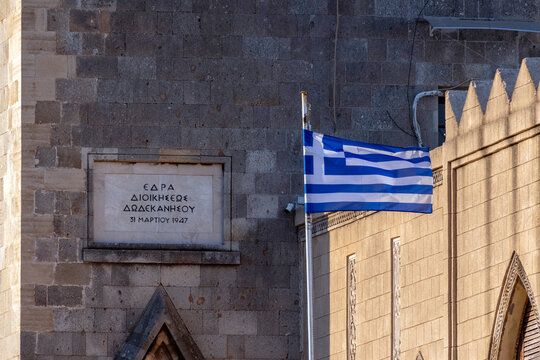 Building and Greek flag near historical site in Rhodes