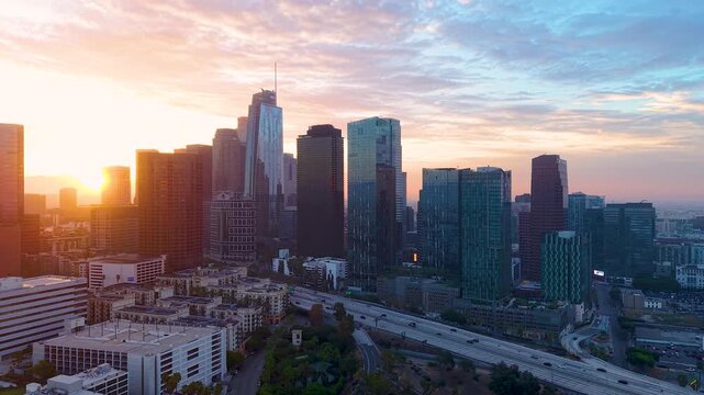 Los &Aacute;ngeles City Skyline glowing in the sunrise. Aerial sweeping view of the Skyscrapers sitting quietly atop historical Bunker Hill basking in the morning sun.