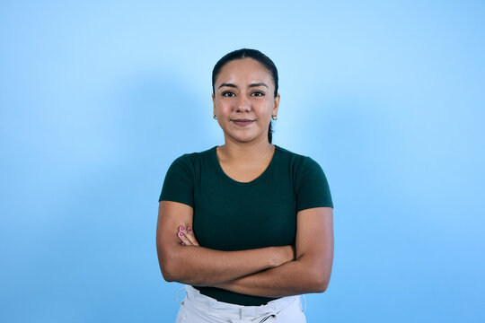 young mexican brunette woman on blue background in Mexico Latin America, portrait of latina girl with copy space 
