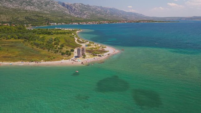 High aerial view of Vecka Kula tower ruins standing on a turquoise beach in Starigrad Paklenica, Croatia