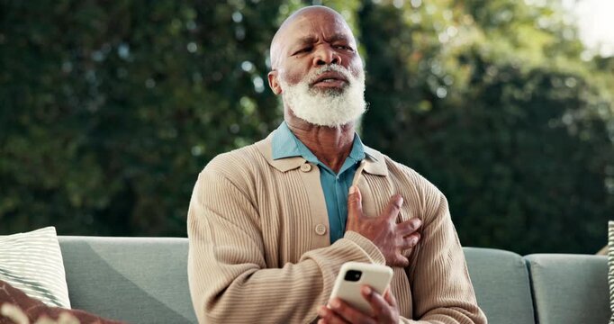 Senior, phone or black man with chest pain for cardiac arrest, heart attack or hypertension. Elderly, male person or ache with smartphone on sofa for health risk, medical emergency or asthma in yard