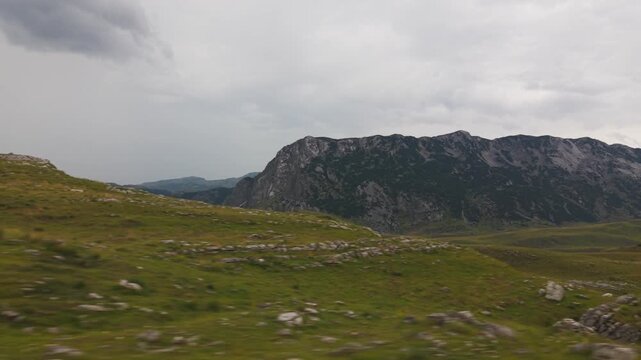 Scenic view of misty rolling green hills and fog-covered mountains in Durmitor National Park, Montenegro