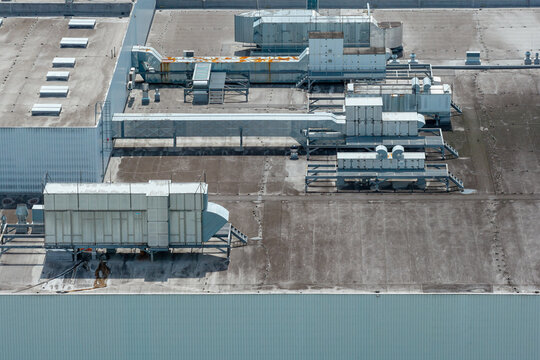 Aerial view of an advanced decorative packaging solutions factory roof featuring industrial HVAC equipment, ventilation ducts, and cooling units in Poland.