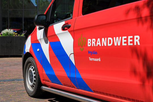 Dutch Fire Department logo sign on the side of a car with text Brandweer. Fire Department sign on red fire fighter vehicle with white and blue stripes.	