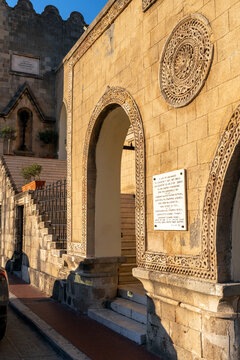 Historic building with stone architecture and arches located in Rhodes during the early evening light