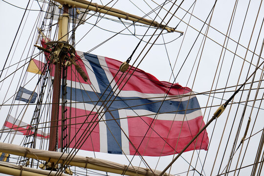 Masts, ropes and and a large norwegian flag in the harbour.of Harlingen Friesland The Netherlands