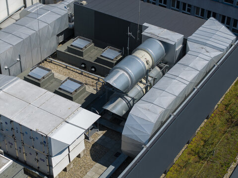 Aerial view of industrial mechanical ventilation equipment and HVAC ducts installed on a modern building rooftop in Krakow, Poland.