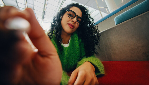 Woman with glasses writing on drawing tablet indoors in casual setting
