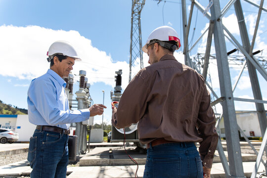 Technician measures electricity at an outdoor substation in Ecuador