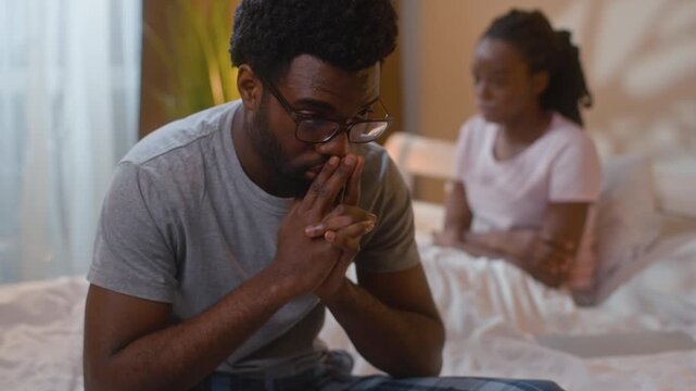 African American couple arguing in bedroom marriage problems angry wife crying frustrated husband yelling family conflict married stress toxic relationship divorce ignoring fight evening home indoors