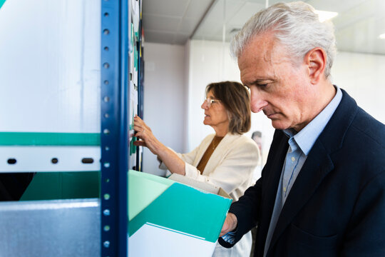 Man and woman search for documents in an office archive