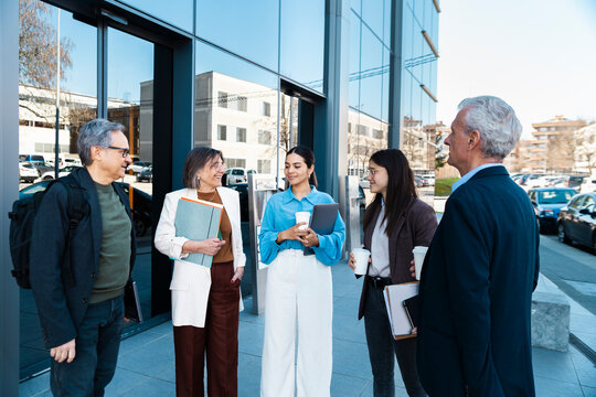 Business team talks during a morning coffee break outside the office