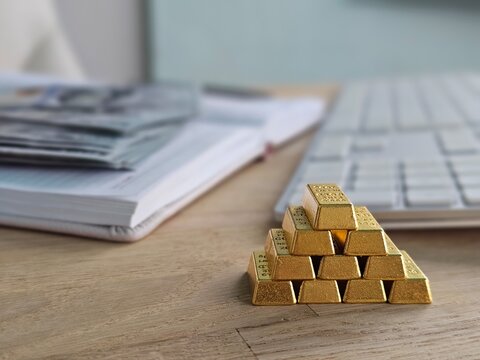 Gold bars arranged in a pyramid shape near a keyboard