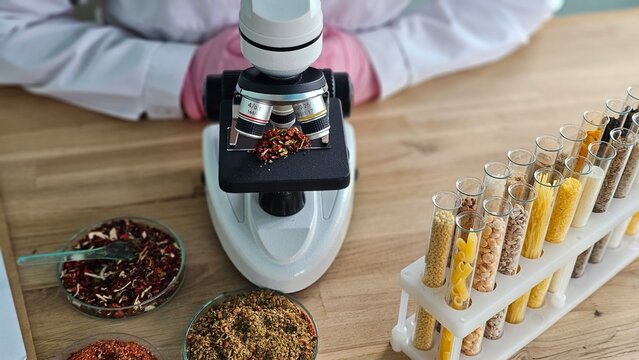 Scientist uses microscope to examine spices and grains during research