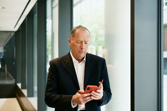 Businessman reads report on smartphone in a coffee shop