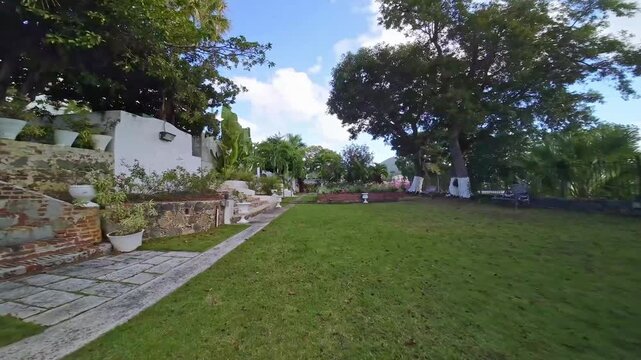 Stunning tropical garden path walk towards scenic coastal fountain vista within peaceful estate grounds.