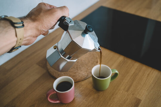 Close up of male hand pouring fresh coffee from moka pot