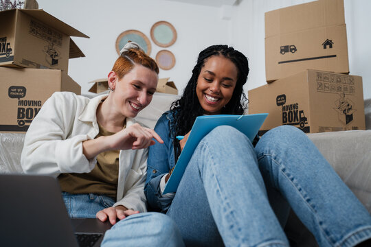 Happy couple planning move at home with laptop and checklist