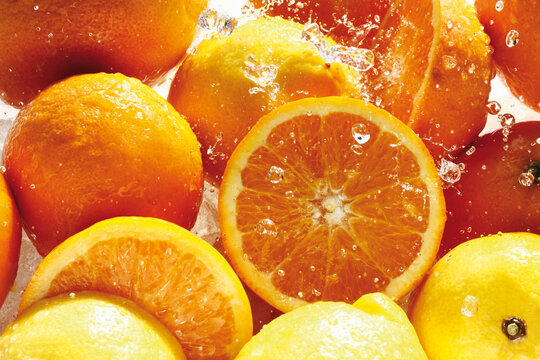 Water splashing on oranges and lemons