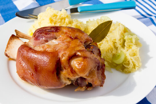 Knuckle of pork with sauerkraut and mash on table