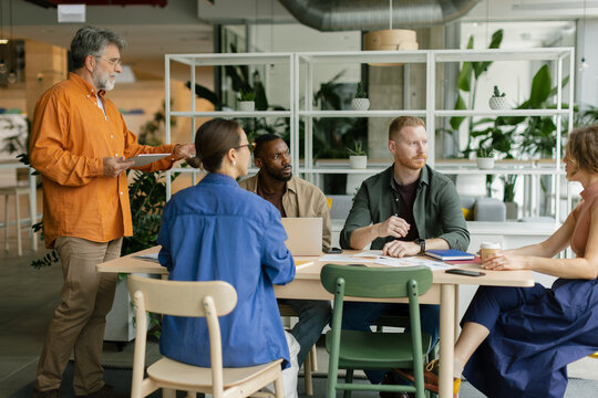 Man gives a presentation to a business team in the coworking office