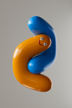 Colorful 3D cartoon character hugging a blue shape with a smile