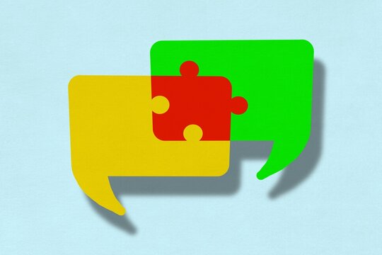 Two overlapping speech bubbles form a puzzle piece solution