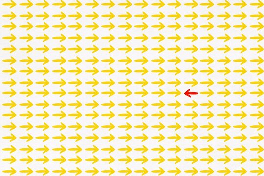 One red arrow points left among many yellow arrows pointing right