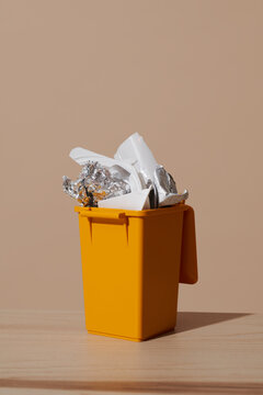 Yellow recycling bin with plastic packaging waste indoors for sustainability
