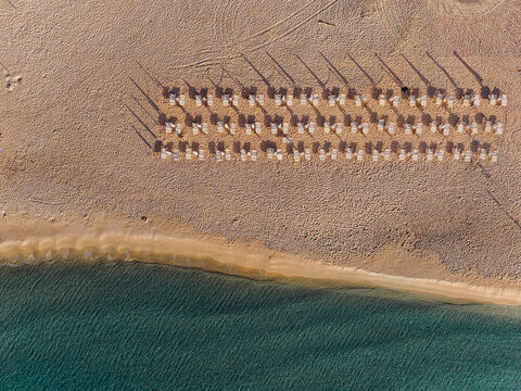 An aerial drone captures a symmetrical beach resort on the coastline