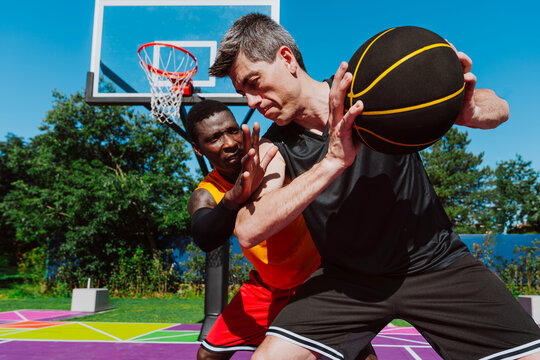 Male players competing in a streetball game on an outdoor court