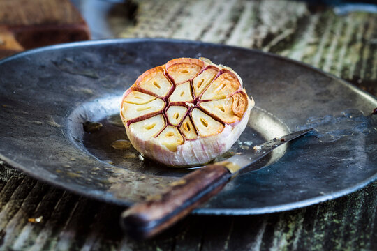 Roasted garlic on plate, knife