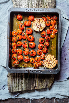Tomatoes and garlic in olive oil, baking tray