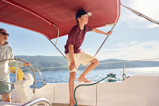 Mother and teenage boy sail a sailboat on the ocean in Croatia